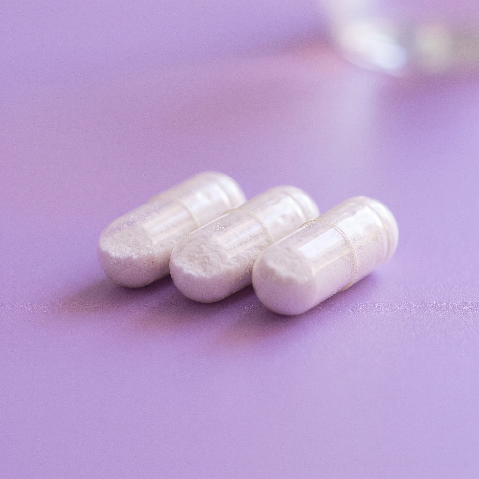 Cápsulas de M∞n Blend TRESSO Suplementos sobre superficie color lila
